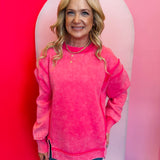 Fuchsia acid wash fleece sweatshirt with exposed seams, relaxed fit, and side slits.
