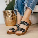 Black embellished double-strap slip-on sandals featuring a cushioned sole and a trendy, versatile design. The straps are adorned with eye-catching details, offering both comfort and style in a sleek silhouette.