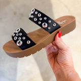 Black embellished double-strap slip-on sandals featuring a cushioned sole and a trendy, versatile design. The straps are adorned with eye-catching details, offering both comfort and style in a sleek silhouette.
