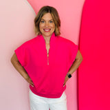 Hot pink half-zip high neck top with a soft, smooth finish, styled for a cozy yet trendy summer look.