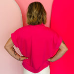 Hot pink half-zip high neck top with a soft, smooth finish, styled for a cozy yet trendy summer look.
