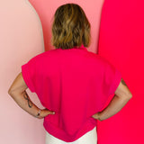Hot pink half-zip high neck top with a soft, smooth finish, styled for a cozy yet trendy summer look.