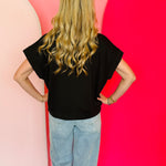 Black scuba high neck top with half zip, displayed folded and styled with denim for a casual-chic look.
