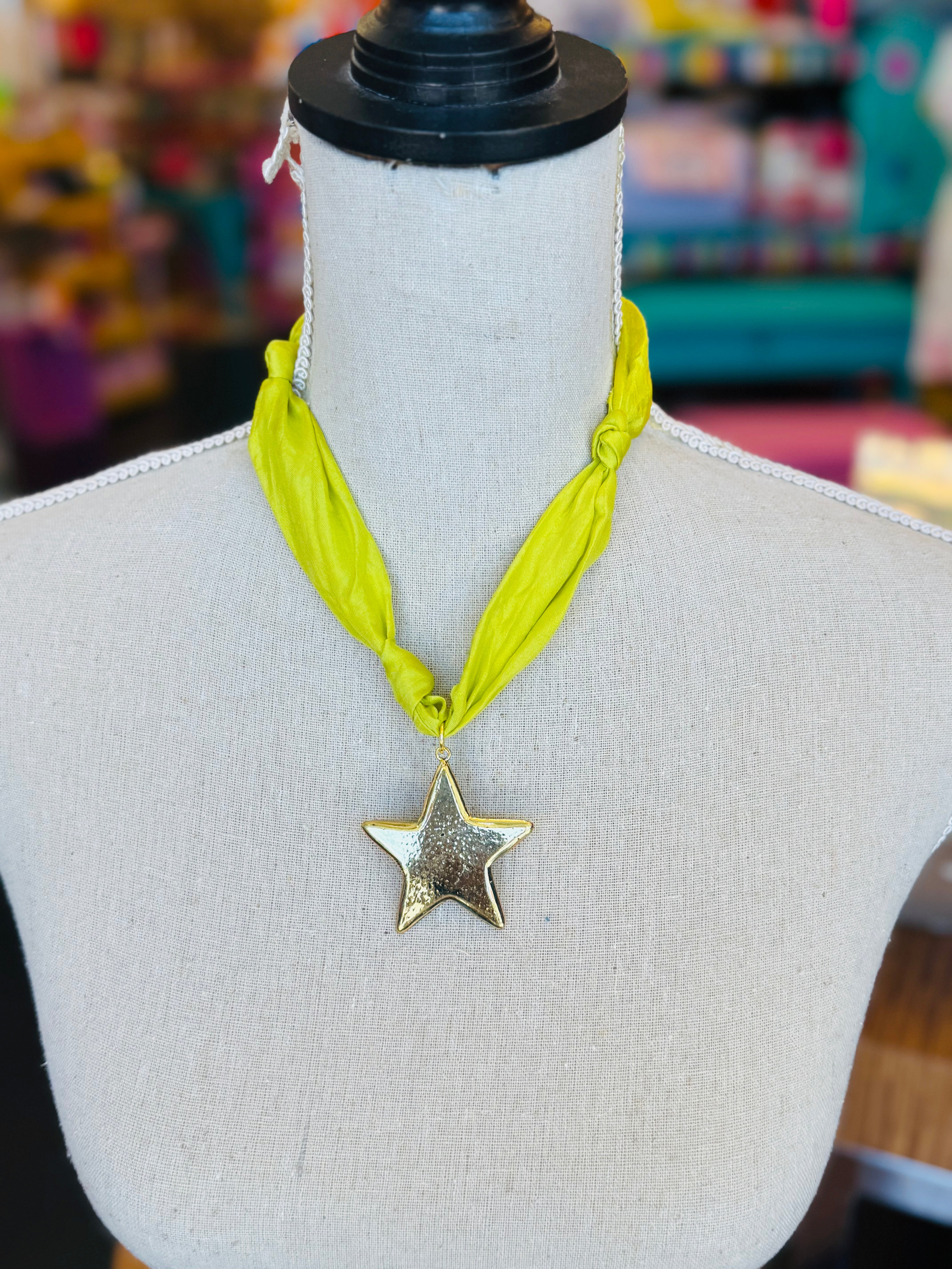 Lime green scarf necklace with a gold star charm, displayed on a neutral background. Lightweight and playful, this accessory adds a pop of color and whimsical shine to any outfit.