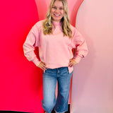 pink acid wash fleece sweatshirt with exposed seams, side slits, and a bottom band.
