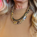 A matte gold layered necklace set featuring leopard print links and black accents.