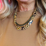 A matte gold layered necklace set featuring leopard print links and black accents.