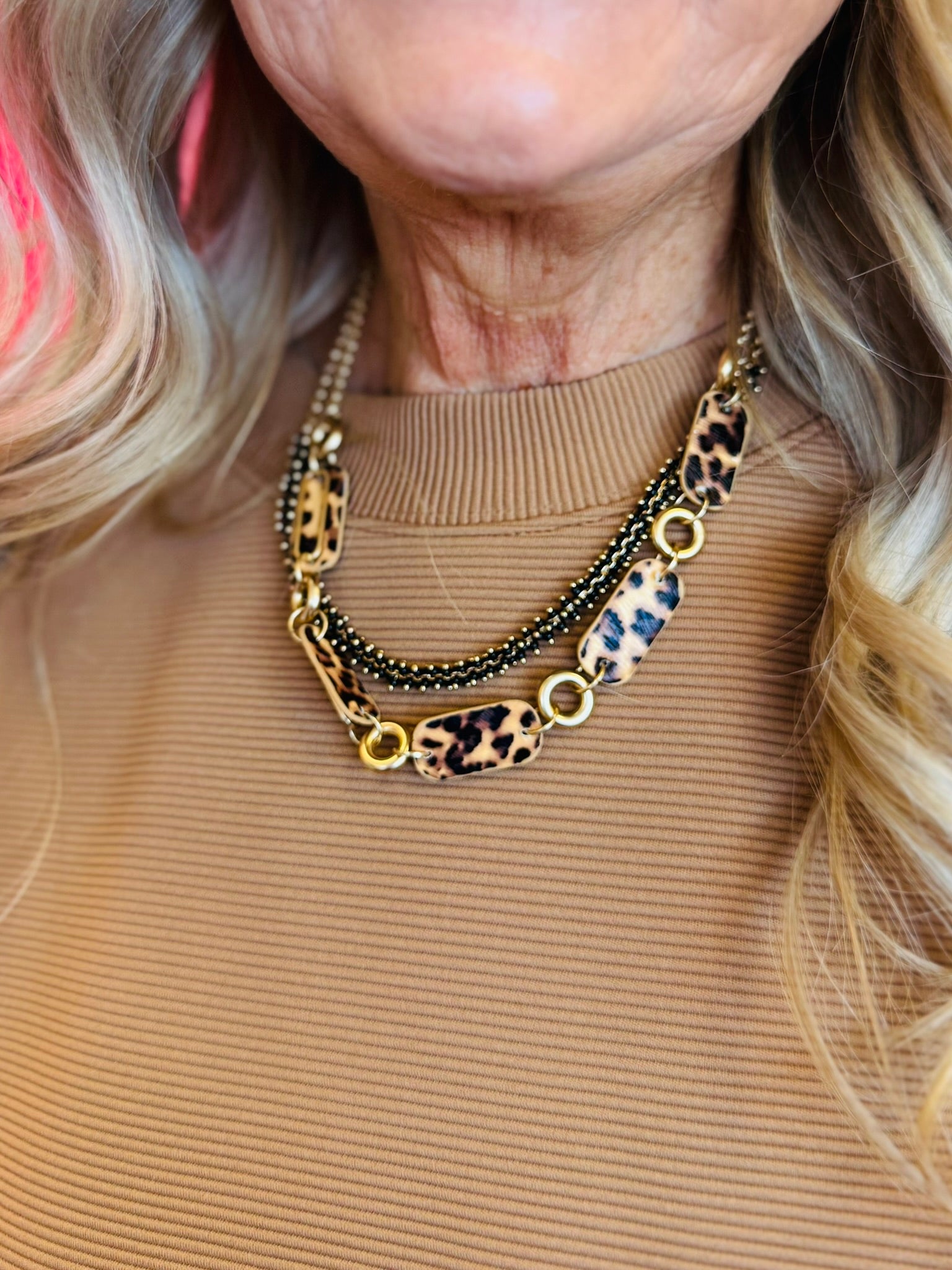 A matte gold layered necklace set featuring leopard print links and black accents.