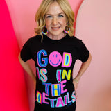 Black graphic tee with "God Is In The Details" in neon colors.