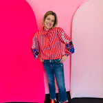 Red and white striped cotton blouse with puff sleeves, floral embroidery, and ruffle trim detail.