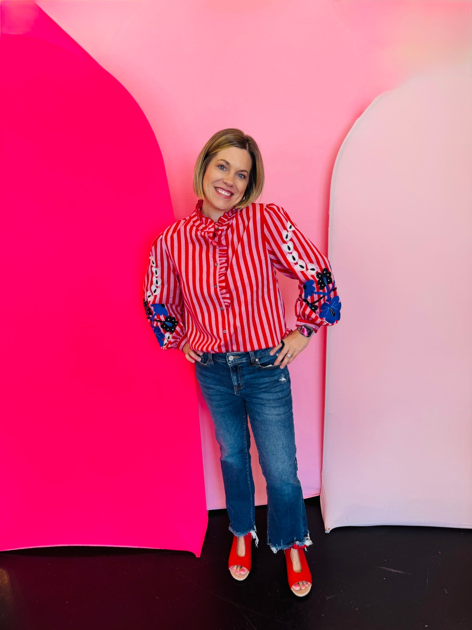 Red and white striped cotton blouse with puff sleeves, floral embroidery, and ruffle trim detail.