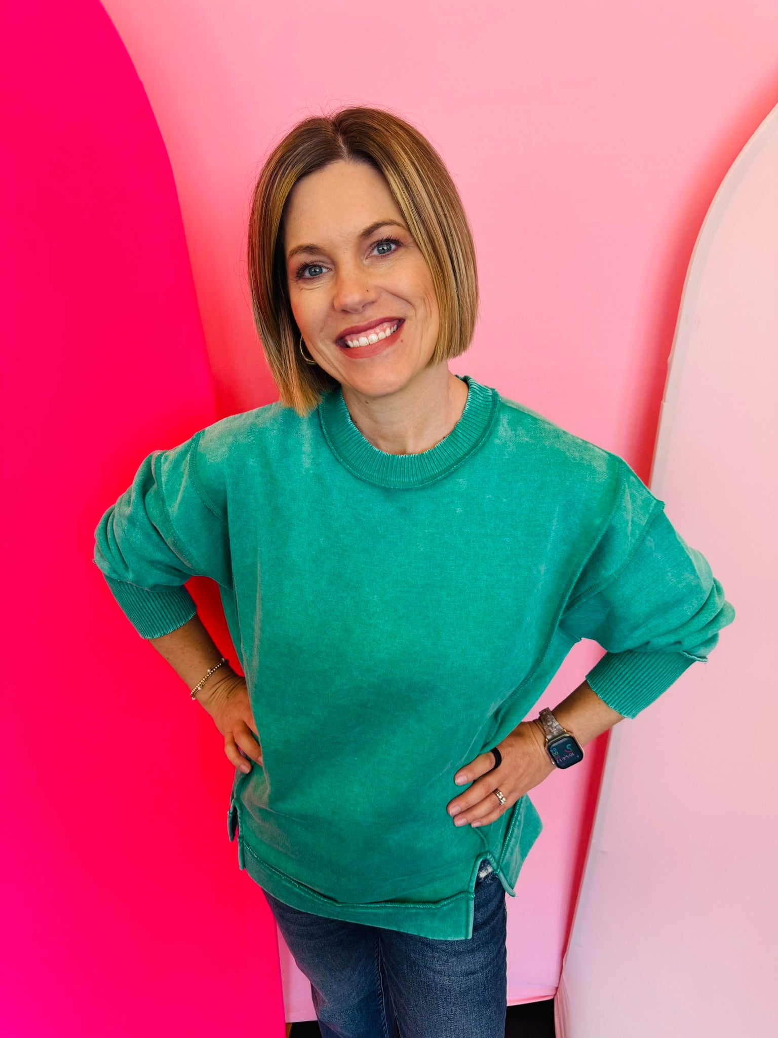 A relaxed-fit, kelly green acid wash fleece sweatshirt. The sweatshirt has visible exposed seams and a side slit at the bottom.
