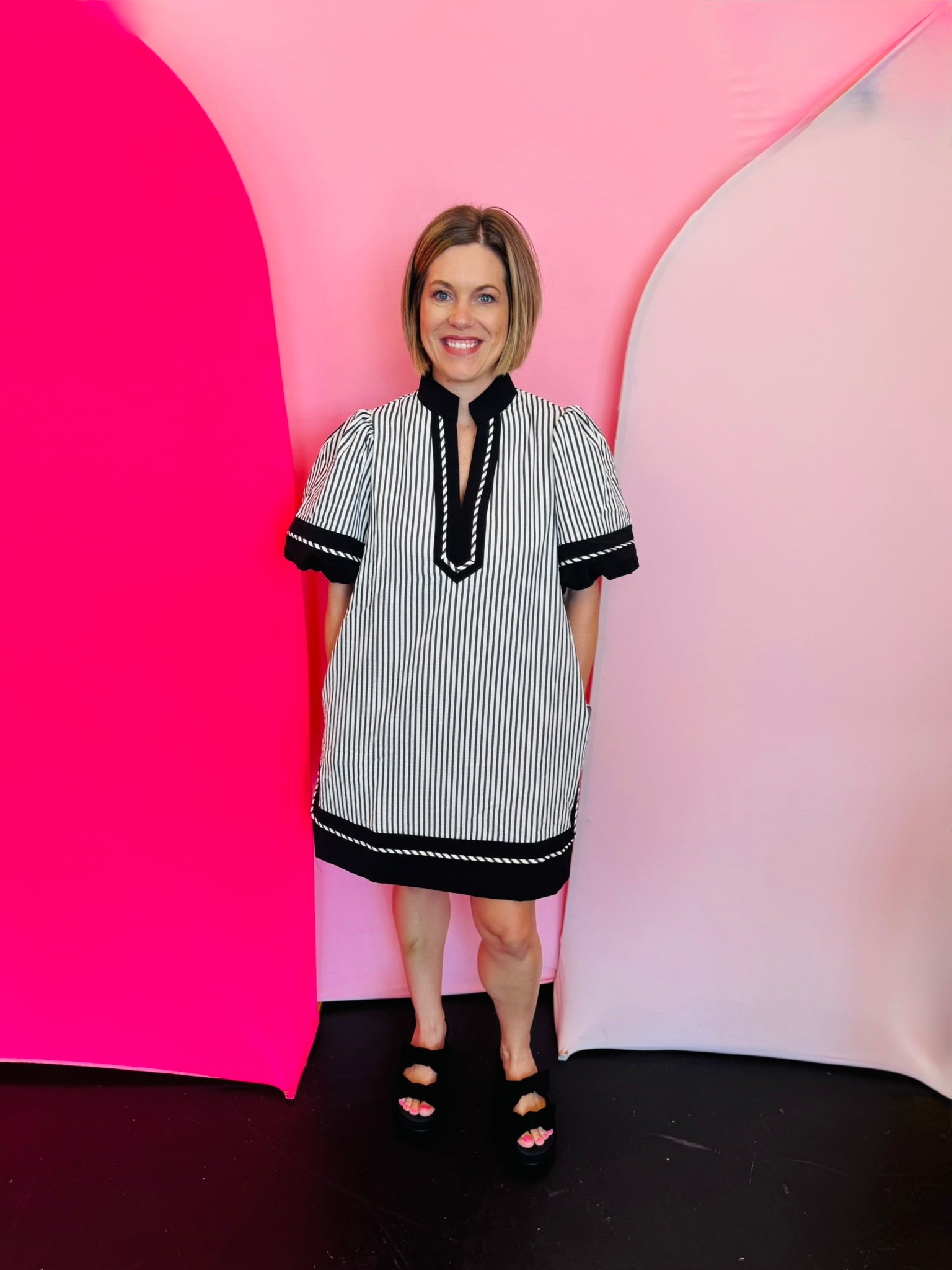 Black and white striped mini dress with lantern sleeves, caftan neckline, and contrast trim.