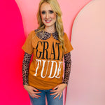 Rust colored tee with bold black and white lettering saying "gratitude"