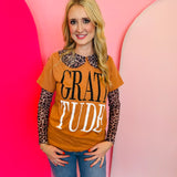 Rust colored tee with bold black and white lettering saying "gratitude"