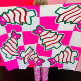 Pink checkered blanket with Christmas treats and pink bow design.