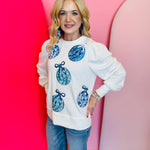 White sweatshirt with blue sequin ornaments.