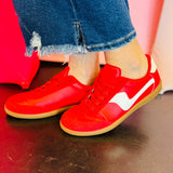 Red leather and suede sneakers with white accents and red laces.