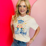 Cream tee with blue rhinestone nutcracker, rhinestone snowflakes, "Son Of A Nutcracker" lettering.