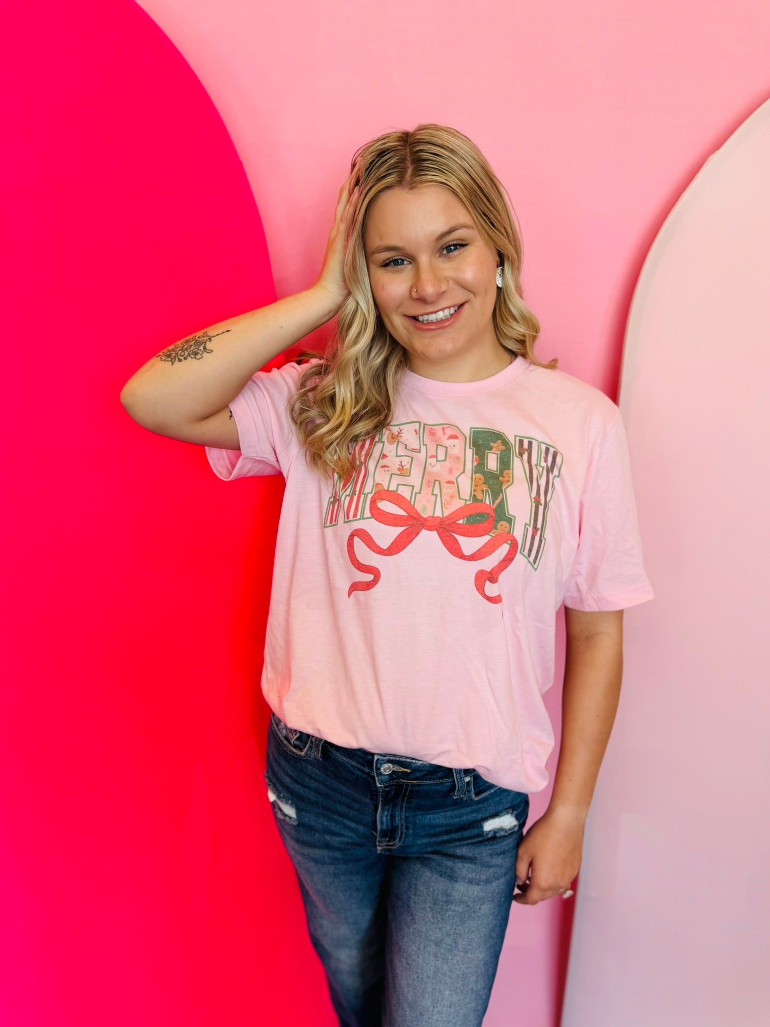 Pastel pink “Merry” sublimated Christmas tee with bow, reindeer and gingerbread men.