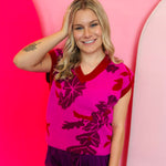 Fuchsia floral knit vest with V-neck and ribbed trim at sleeves and hem.