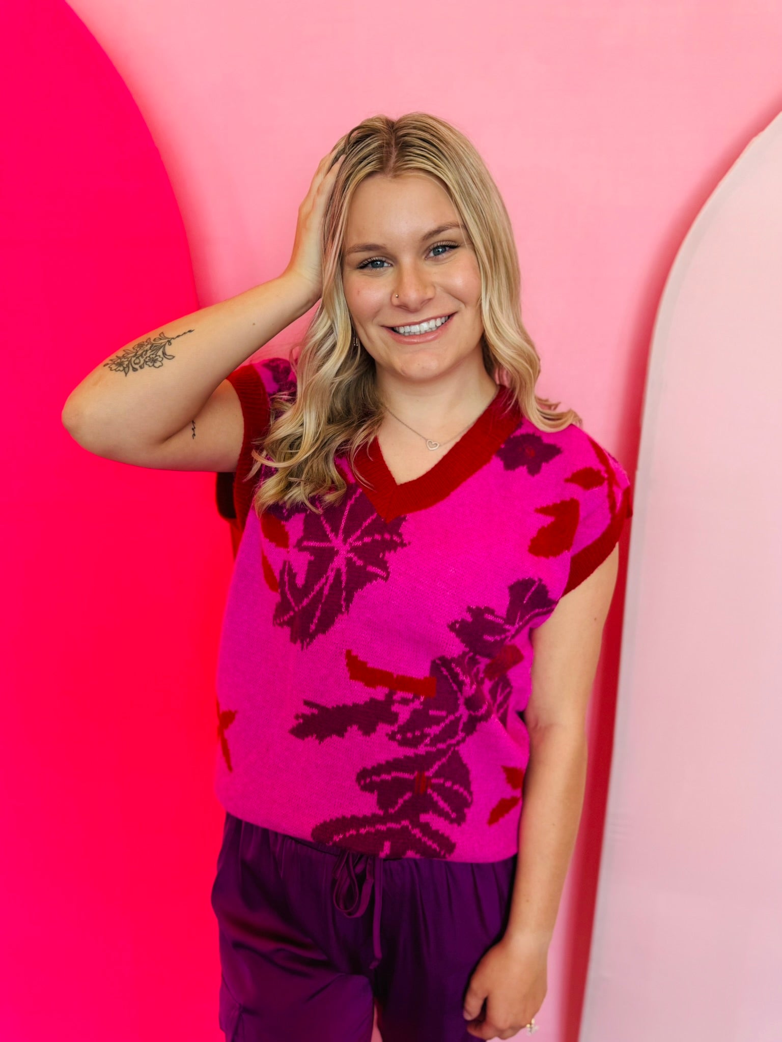 Fuchsia floral knit vest with V-neck and ribbed trim at sleeves and hem.