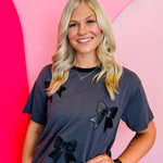 Oversized tee with faux leather bow, embroidered detailing, and contrasting collar.