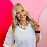 Model wearing the White & Fuchsia Scarf Necklace with pearl-studded heart charm, styled around the neck for a bold and flirty statement look.