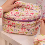 Quilted travel bag with zip closure and top handle, perfect for beauty or toiletry essentials.