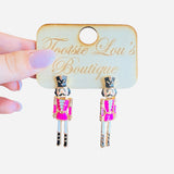 Pink and gold nutcracker soldier earrings with black and gold hat, festive lightweight accessory.