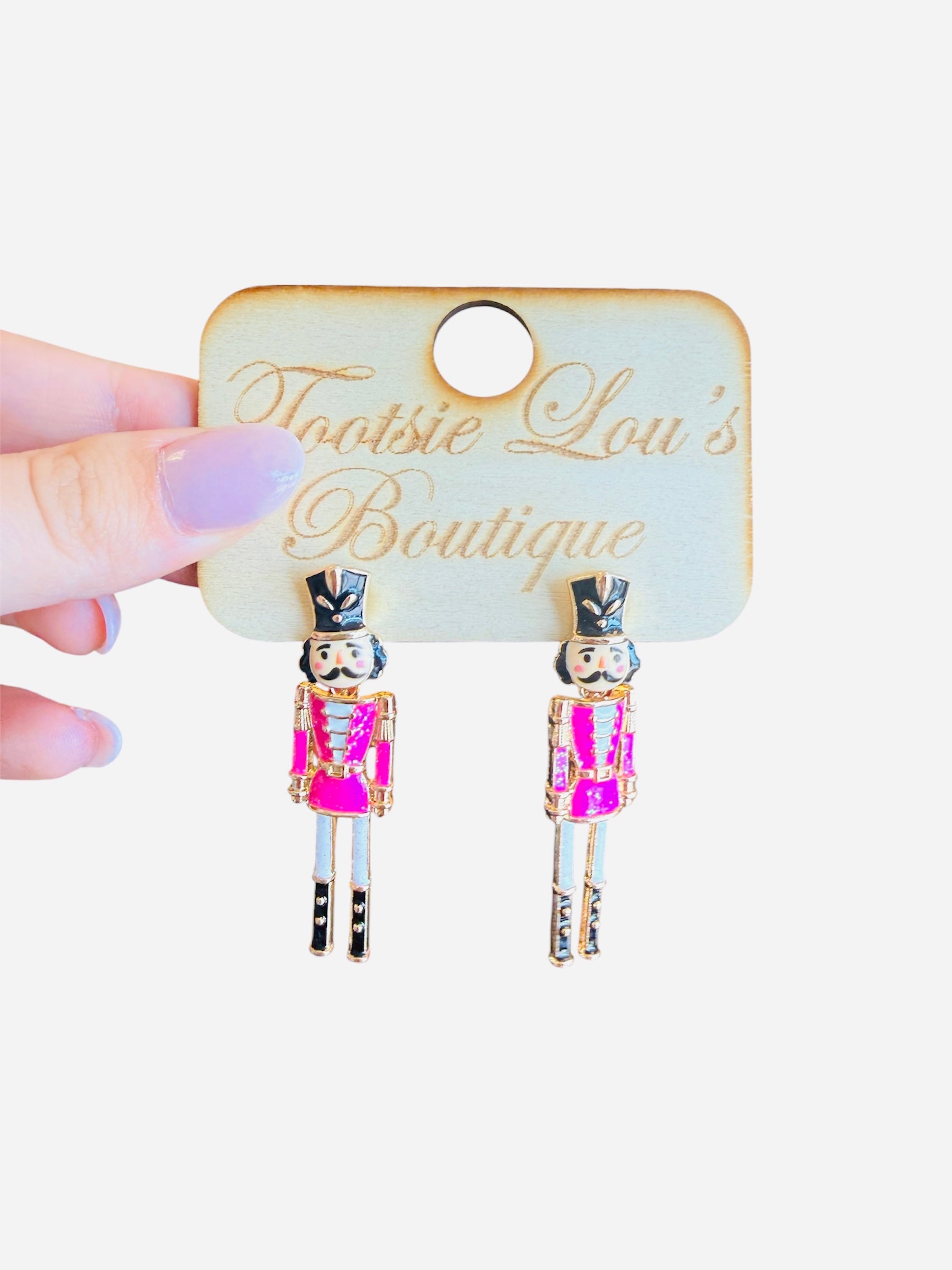 Pink and gold nutcracker soldier earrings with black and gold hat, festive lightweight accessory.