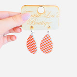 Orange and white checkered teardrop earrings in glossy acrylic, lightweight and perfect for bold style.