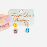Pastel rhinestone dangle earrings with pink, yellow, and blue stones framed in gold trim.