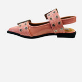 Pink pointed-toe flats with bold silver double buckle straps and a slingback backstrap, combining vibrant color with edgy charm.