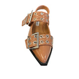 Tan pointed-toe flats with bold silver double buckle straps and a slingback backstrap, combining vibrant color with edgy charm.