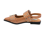 Tan pointed-toe flats with bold silver double buckle straps and a slingback backstrap, combining vibrant color with edgy charm.