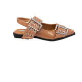Tan pointed-toe flats with bold silver double buckle straps and a slingback backstrap, combining vibrant color with edgy charm.