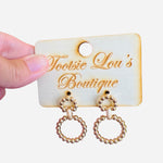 A pair of gold earrings, each featuring two interlinked hoops. Both hoops are adorned with a detailed, textured beaded pattern.