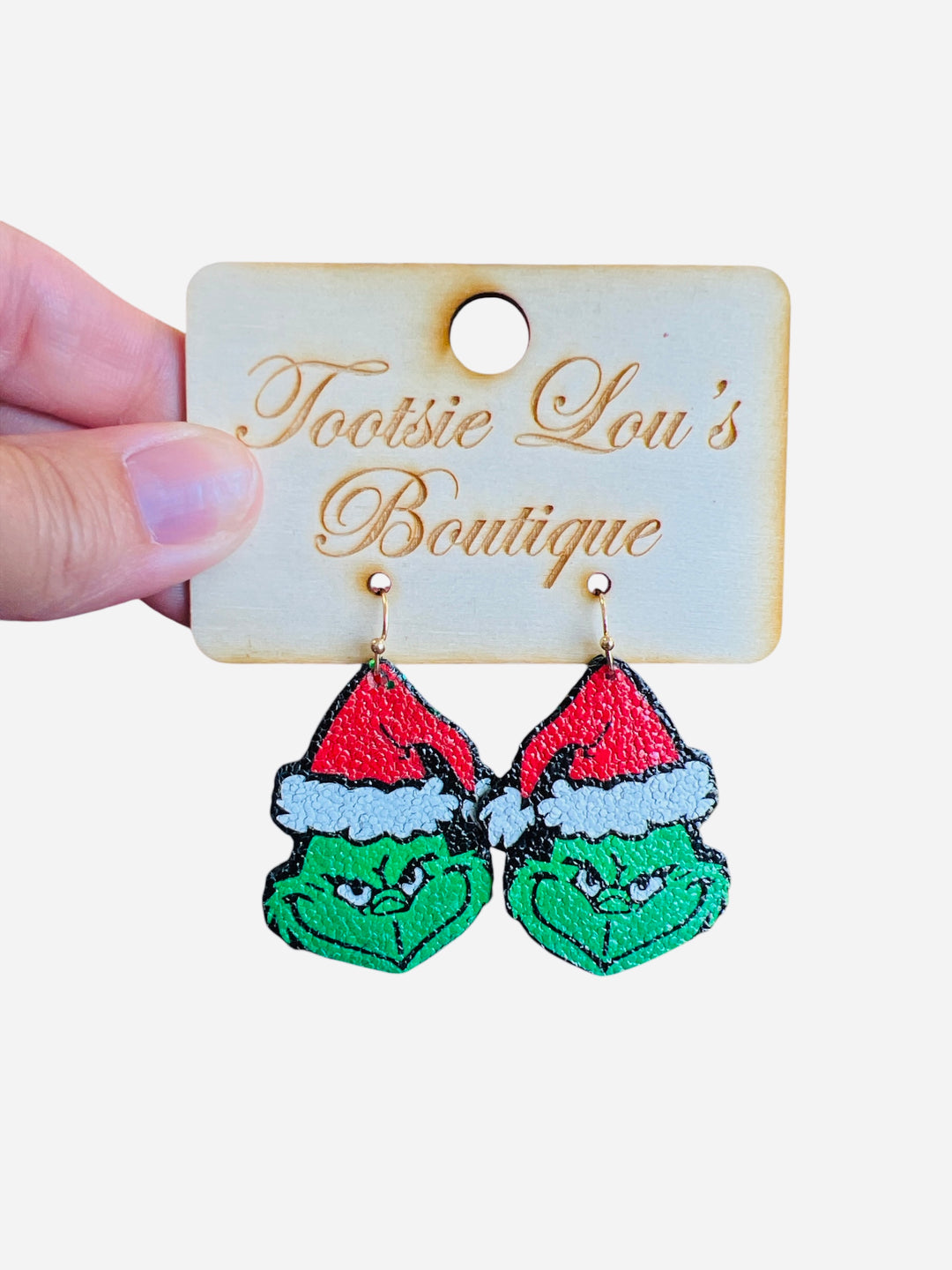 A pair of stud earrings, each featuring the Grinch's green face wearing a red and white Santa hat.