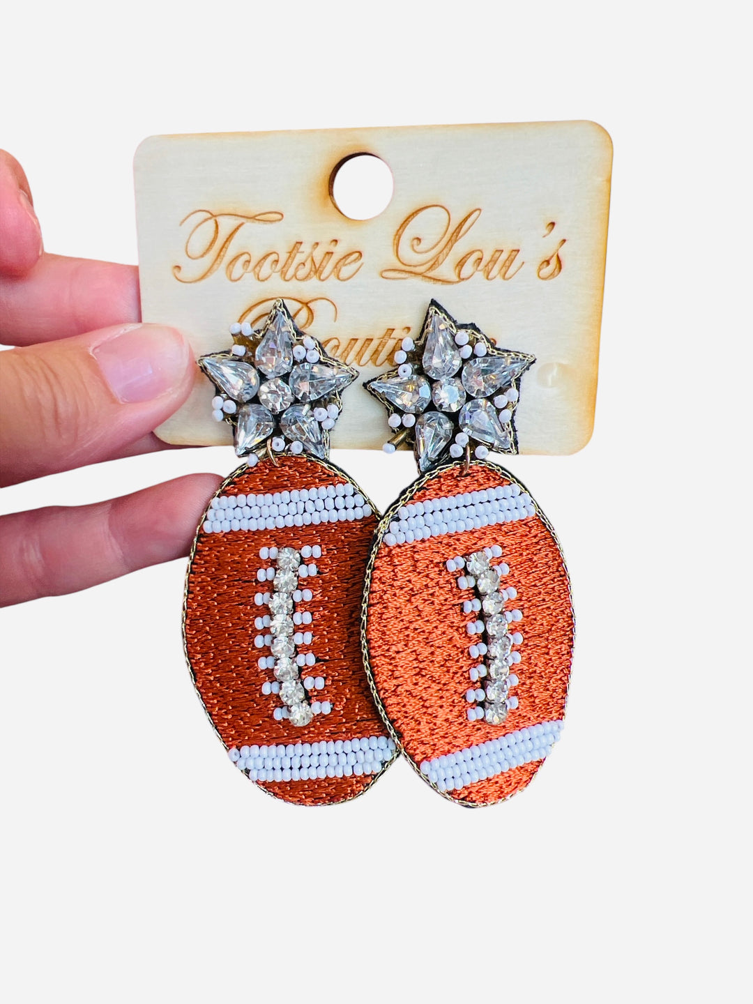 Beaded and rhinestone embellished football earrings set on rhinestone stud.