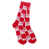 A pair of plush, soft crew socks with a red and white checkerboard pattern. Inside the white squares, there is a repeating pattern of Santa Claus faces.