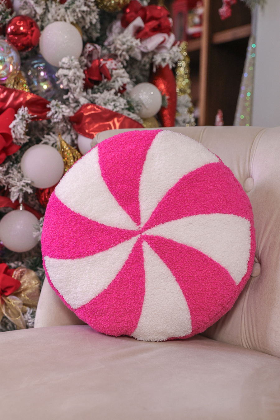 Round pink peppermint swirl pillow, 14-inch diameter, soft and festive holiday decor.
