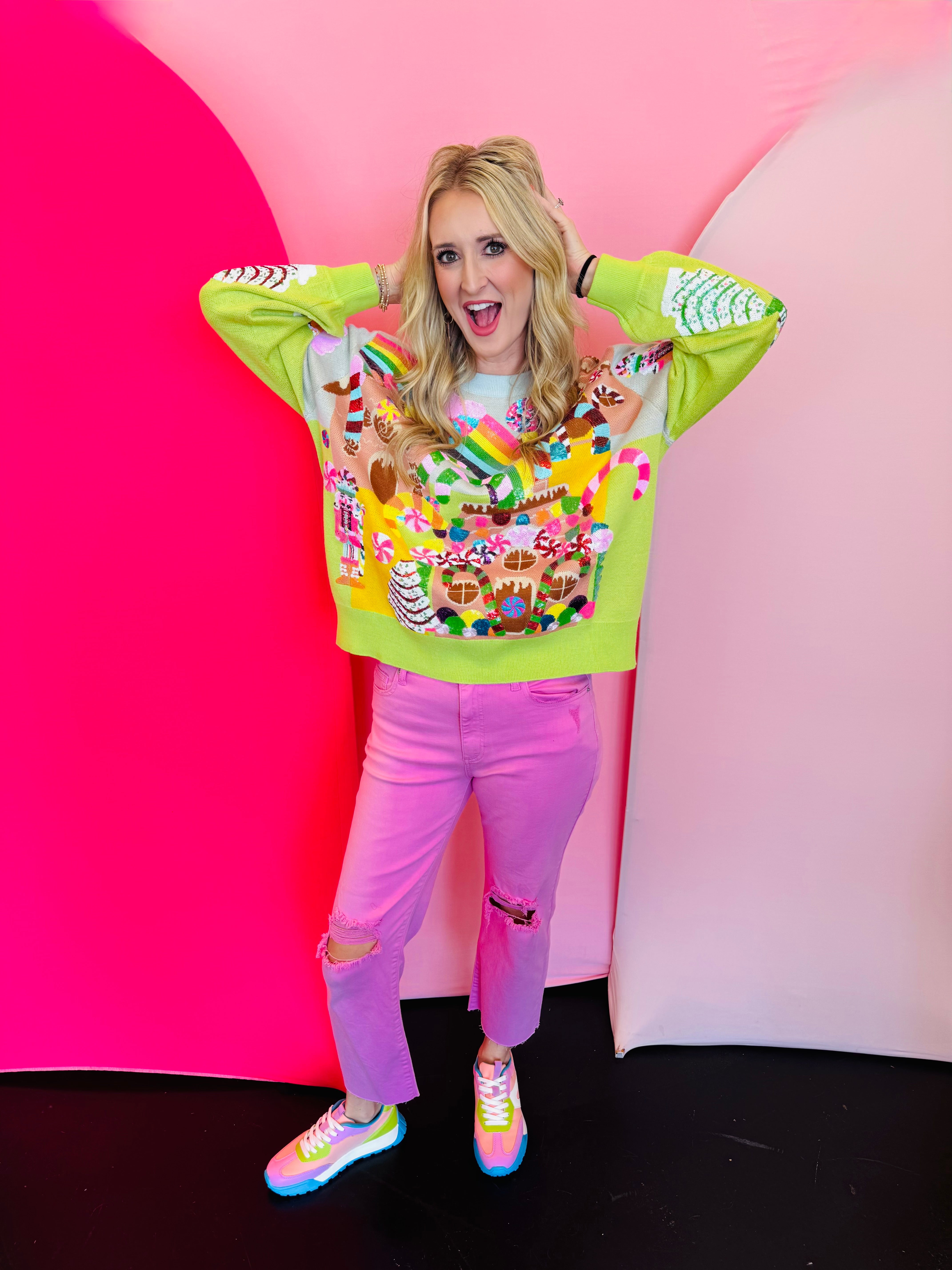 Lime green Christmas sweater with sequin gingerbread village, candy canes, nutcrackers, and rainbows.