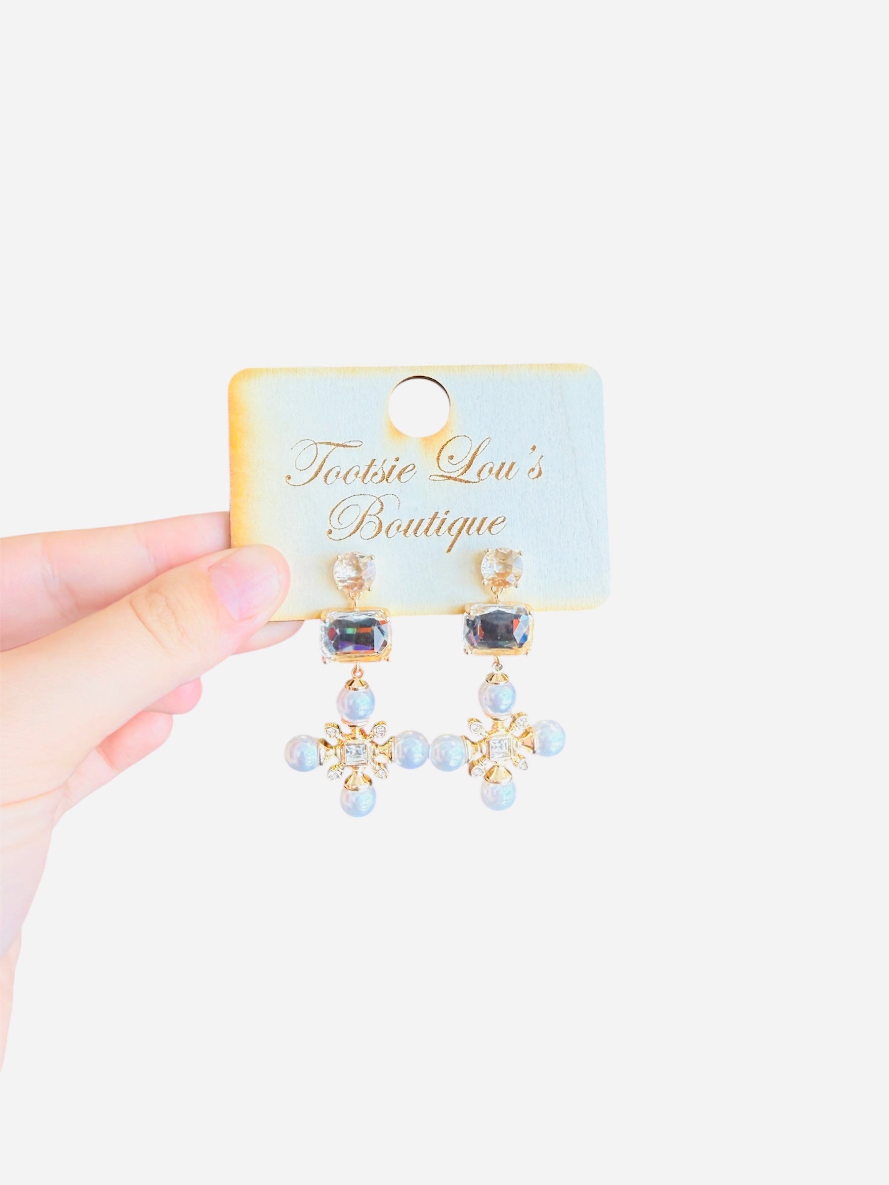 Elegant rhinestone earrings with round, rectangular, and snowflake-inspired design with square and pearl rhinestones.