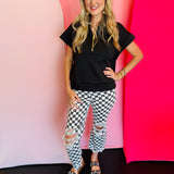 Black and white cropped checkered jeans with knee distressing.