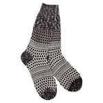A pair of plush, soft crew socks featuring a black and white patchwork design with various geometric patterns, stripes, and textured sections.