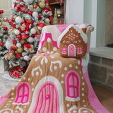 Pink blanket with gingerbread house and candy-colored details, 50x57 inches.