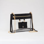 Clear crossbody bag with black trim and matching hardware, featuring a detachable sunglasses holder—elegant and event-ready.