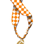 Orange and white checkered knotted scarf necklace with gold football charm.