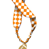Orange and white checkered knotted scarf necklace with gold football charm.